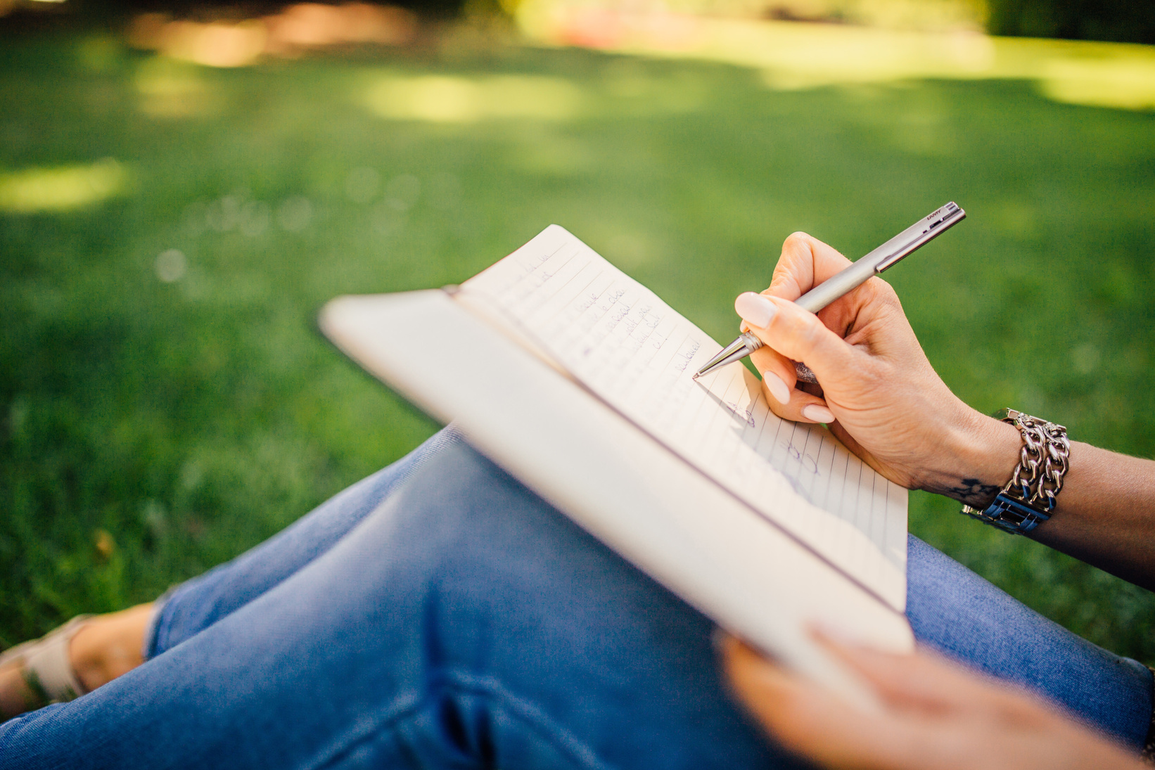 Woman Writing on a Notebook Outdoors